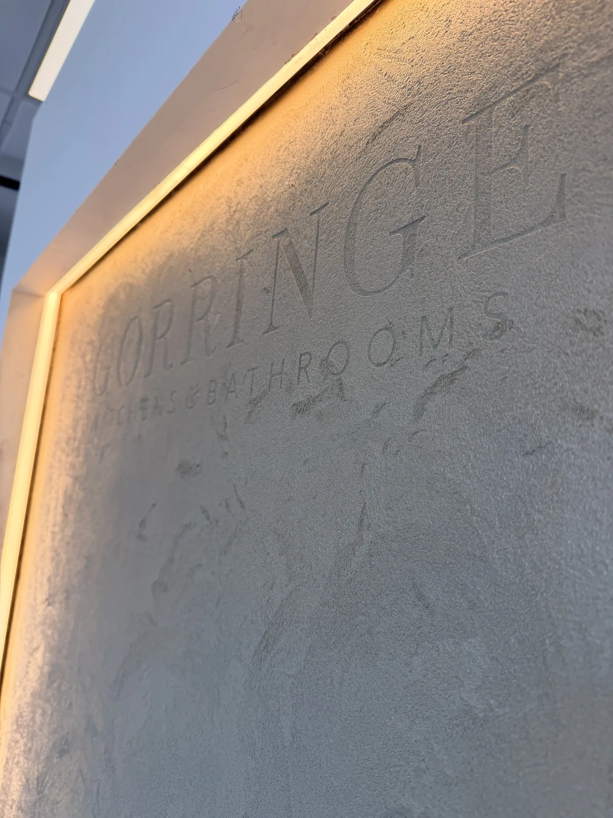 Gorringe Kitchens and Bathrooms lettering worked into a textured Oltre STY 48 showroom wall