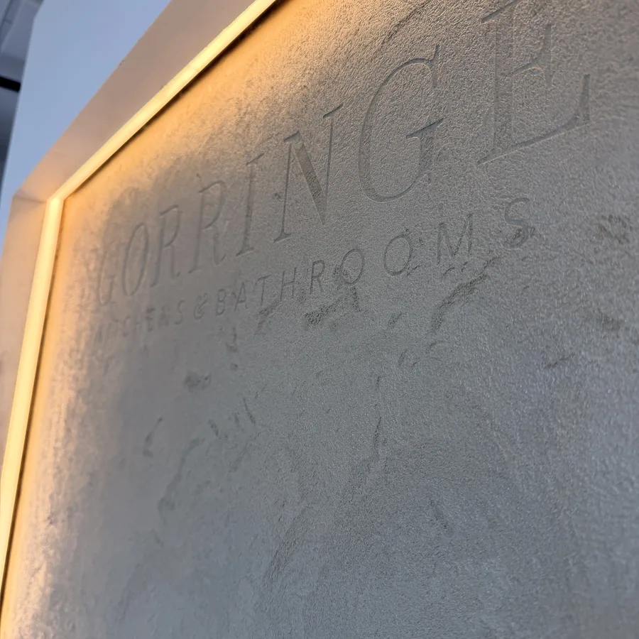 Bespoke lettering worked into a textured commercial microcement showroom wall