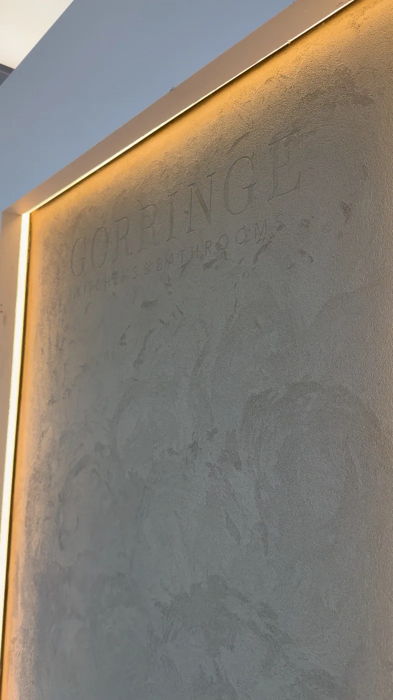 Backlit Gorringe Kitchens and Bathrooms lettering worked into a textured Oltre showroom wall