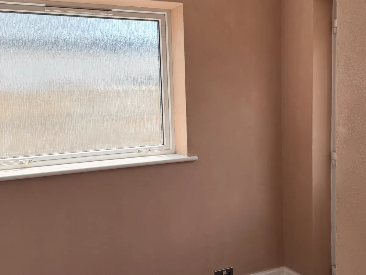 Floated Oltre Style 22 microcement finish on a wall, running into the window reveal and around the corner return