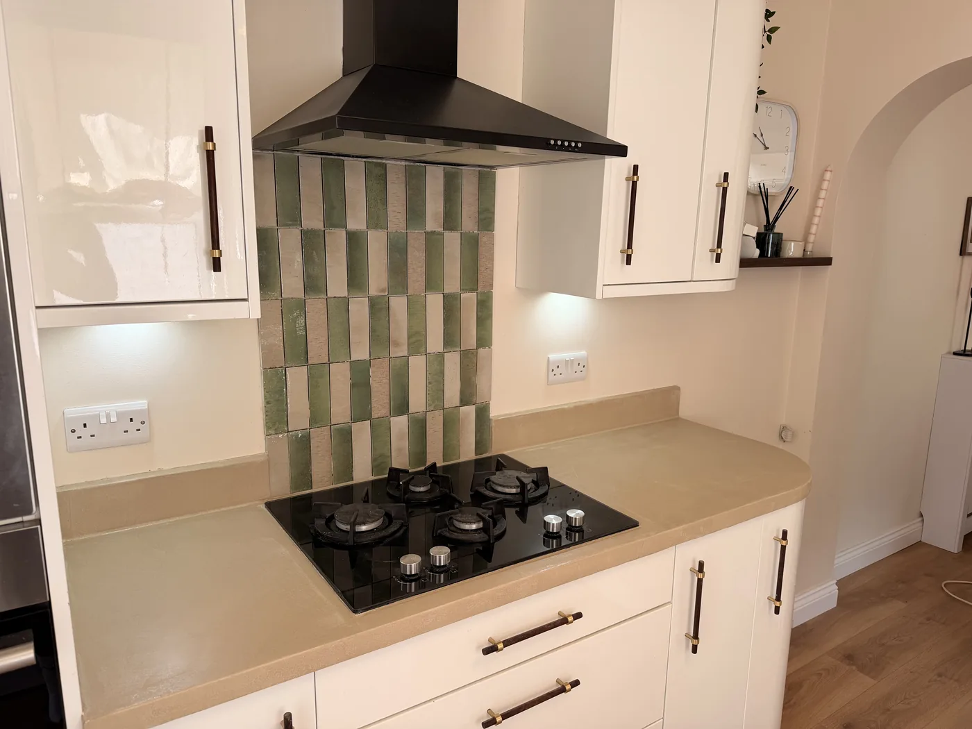 Microcement worktop finished around a hob and tiled splashback
